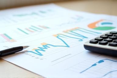 Detailed financial planning documents and calculator on a desk, symbolizing kitchen renovation budgeting.